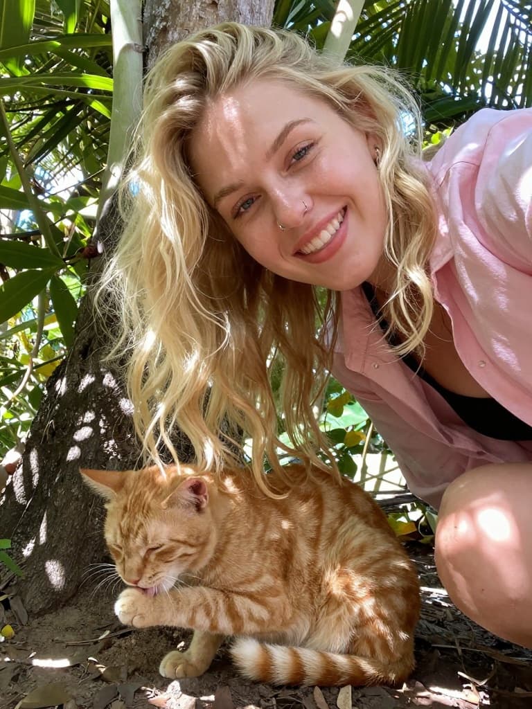 Smartphone selfie taken from a high angle, of a young blonde woman…