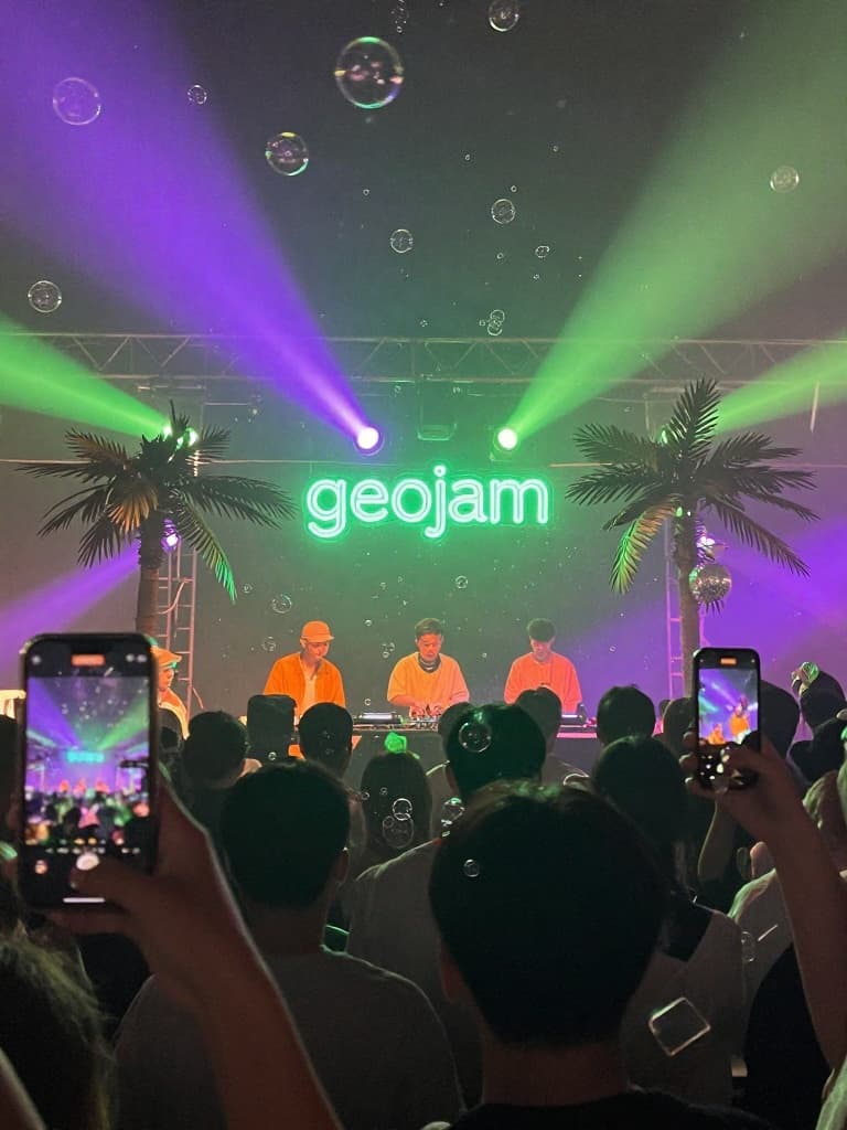 Smartphone photo taken from the crowd at a live event, capturing a DJ…
