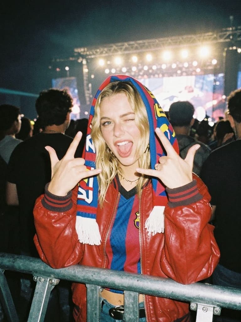 Smartphone photo taken at a night concert of a young blonde woman…