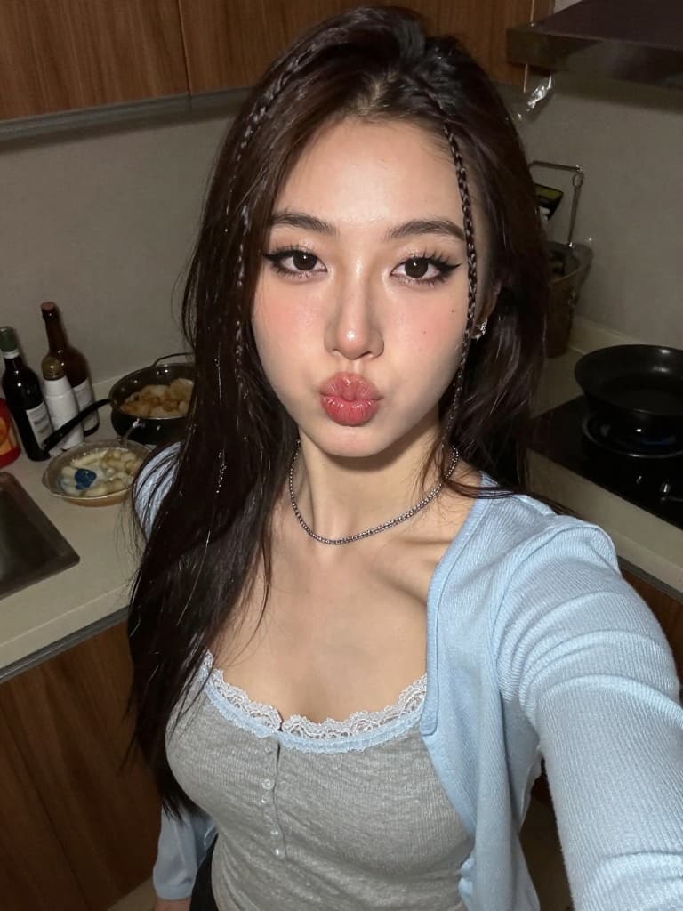 Smartphone selfie of a beautiful young East Asian woman in her messy…
