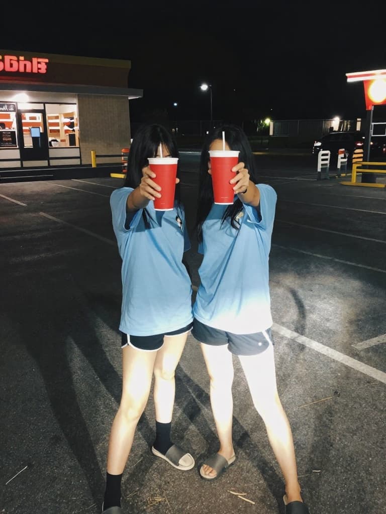 Smartphone photo taken at night of two young women in a fast-food…