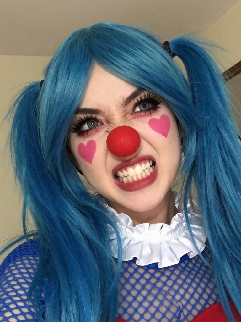 Selfie taken on a smartphone of a young woman with vibrant blue hair…