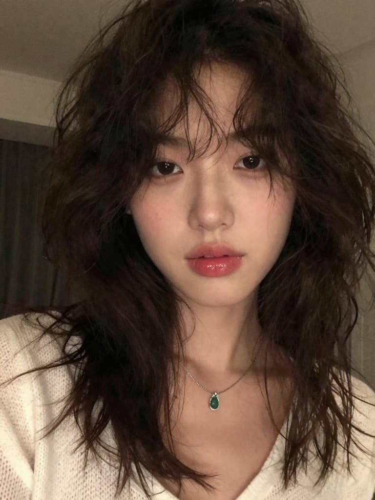 Front-camera smartphone selfie of a beautiful young East Asian woman…